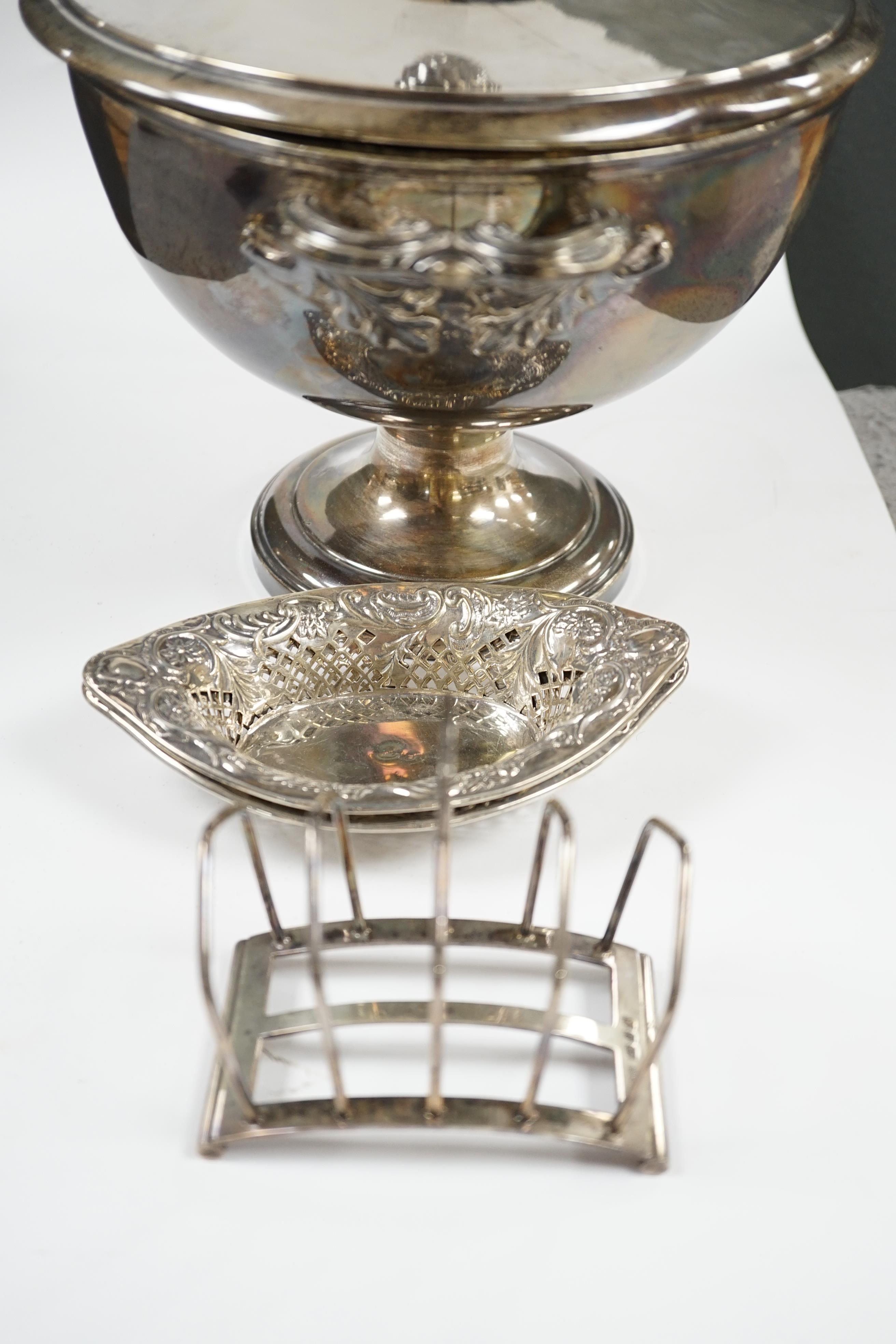 A pair of late Victorian pierced silver navette shaped bonbon dishes, 15.4cm, a silver five bar toast rack and a plated punch bowl and cover. Condition - poor to fair